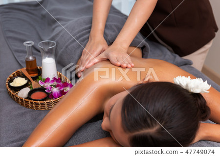 Asian woman enjoying a salt scrub massage at spa. 47749074