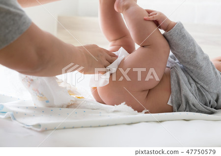 Diaper changing and cleaning bottom of baby 47750579