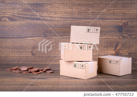 Paper boxes and cash coins on wooden background Paper boxes and cash coins on wooden background 47750722