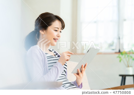 Young woman operating tablet terminal internet girls lifestyle female portrait Young woman operating tablet terminal internet girls lifestyle female portrait 47750808