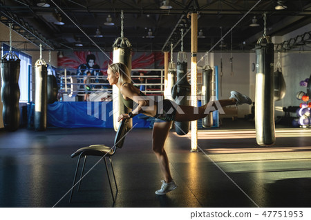 Young woman practicing yoga in gym, working out, wearing sportswear, indoor. Bodyweight exercises 47751953