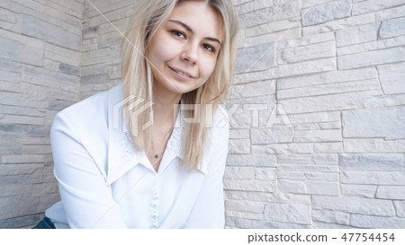 Portrait of attractive young european businesswoman on brick wall background Portrait of attractive young european businesswoman on brick wall background 47754454