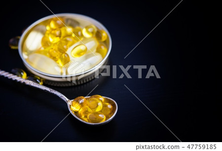 Capsules of fish oil on black background Capsules of fish oil on black background 47759185