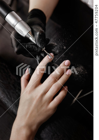 Manicurist in black gloves, grinding machine Manicurist in black gloves, grinding machine 47759204