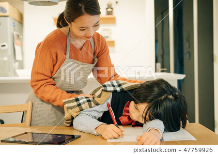 在孩子上穿毯子的母親厭倦了學習入睡 47759926