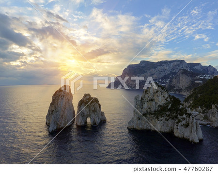 Faraglioni rocks towering up from bright blue Mediterranean waters on the island of Capri, Italy 47760287