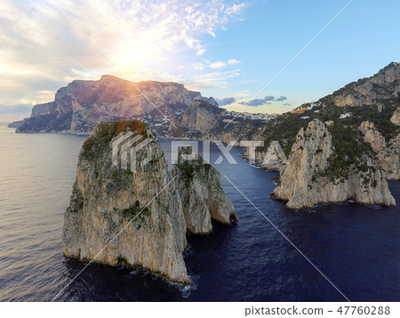 Faraglioni rocks towering up from bright blue Mediterranean waters on the island of Capri, Italy 47760288