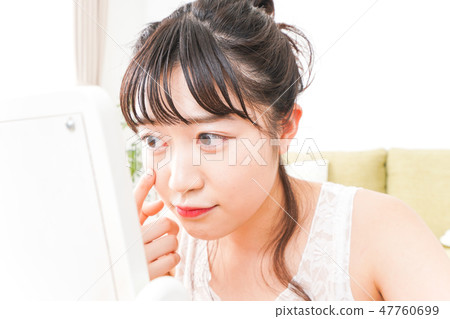A young woman making skin care and makeup A young woman making skin care and makeup 47760699
