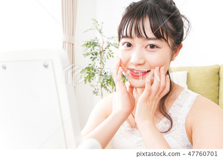 A young woman making skin care and makeup A young woman making skin care and makeup 47760701