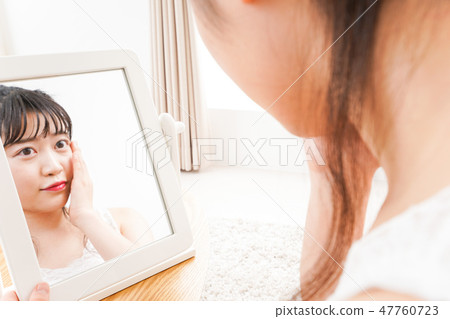 A young woman making skin care and makeup A young woman making skin care and makeup 47760723
