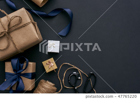 Creative gift boxes on dark background. Wrapping with brown paper Creative gift boxes on dark background. Wrapping with brown paper 47765220