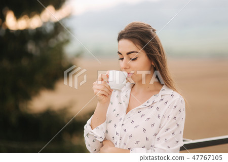 Portrait of beutiful woman outside. She drinking a coffee on terrace Portrait of beutiful woman outside. She drinking a coffee on terrace 47767105