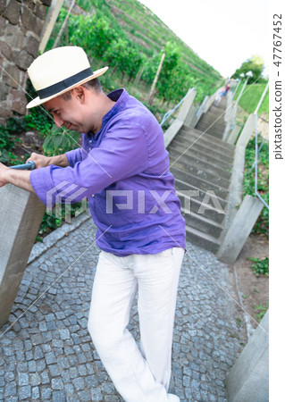 Funny man is fooling around near stone staircase 47767452