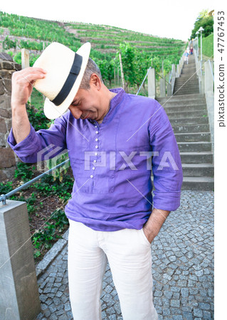 Funny man in hat is fooling around near stairs 47767453