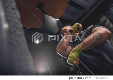 Let's get ready to rumble. Arm workout, professional young boxer with green hands wraps hitting 47768690