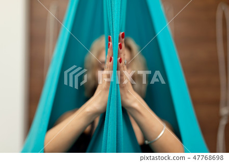 Woman doing fly yoga stretching exercises in gym. 47768698