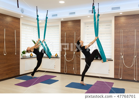Couple womans doing fly yoga stretching exercises 47768701