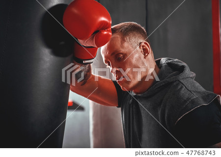 Tired after workout. Tired young athlete in sports clothing looking away after hard training on 47768743