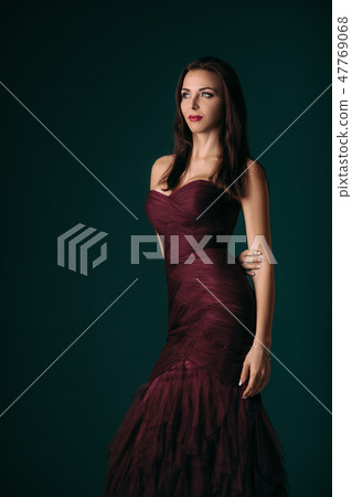 woman in evening dress posing over dark background 47769068