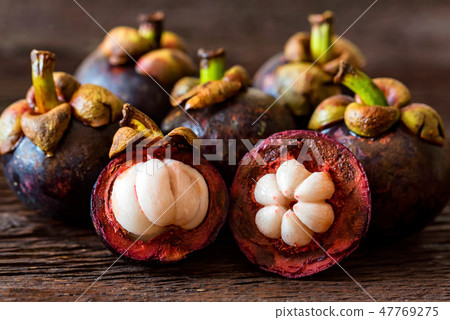 Mangosteen fruit on wooden table close up Mangosteen fruit on wooden table close up 47769275