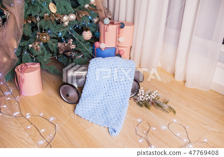 Very gentle and beautiful blankets lie near the New Year tree. Photo session in the photo studio Very gentle and beautiful blankets lie near the New Year tree. Photo session in the photo studio 47769408