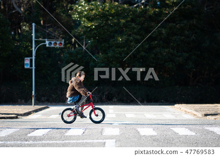 一個女孩在玩一輛自行車 47769583