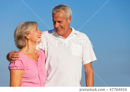 Happy Senior Couple Walking Embracing in Blue Sky Happy Senior Couple Walking Embracing in Blue Sky 47769938