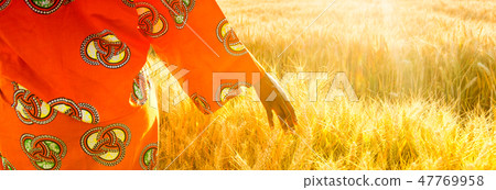 African woman in traditional clothes hand on wheat African woman in traditional clothes hand on wheat 47769958