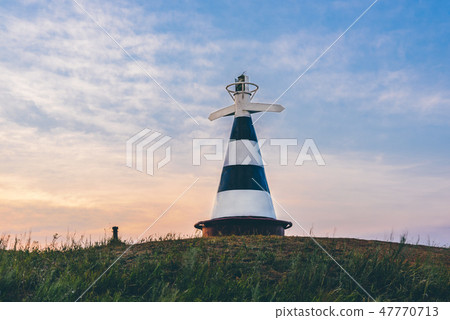 Beacon with pointer on the hill in sunset light Beacon with pointer on the hill in sunset light 47770713