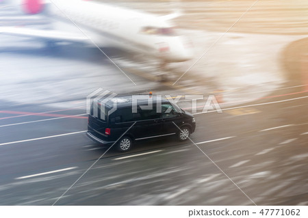 Black VIP service van running on airport taxiway with blurred private jet on background. Business Black VIP service van running on airport taxiway with blurred private jet on background. Business 47771062