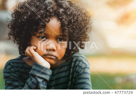 Unhappy little african american kid in the park. Unhappy little african american kid in the park. 47773729