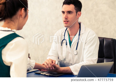 Young doctor examining patient in hospital office. 47773759