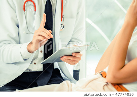 Male Doctor and Female Patient in Hospital Office 47774036