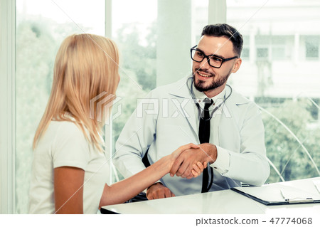 Male Doctor and Female Patient in Hospital Office 47774068