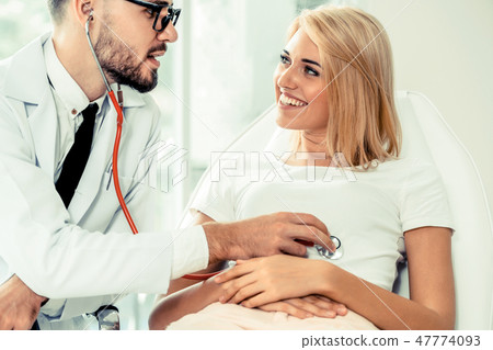 Male Doctor and Female Patient in Hospital Office 47774093