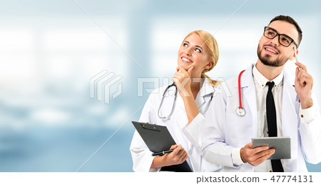 Doctor at hospital works on computer with partner. 47774131