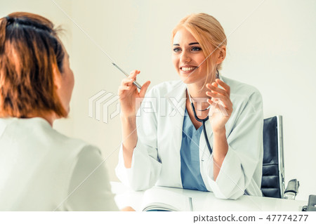 Woman Doctor and Female Patient in Hospital Office 47774277