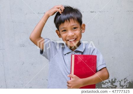 Asian Child Smile with Feeling Happy with a Book. Asian Child Smile with Feeling Happy with a Book. 47777325