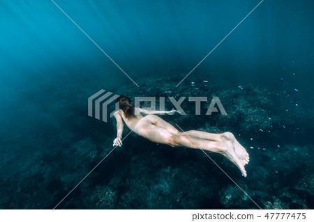 Naked woman dive in blue sea, underwater in sea Naked woman dive in blue sea, underwater in sea 47777475