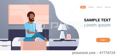 man listening audio book through headphones african americn guy using tablet sitting on bed modern 47778729