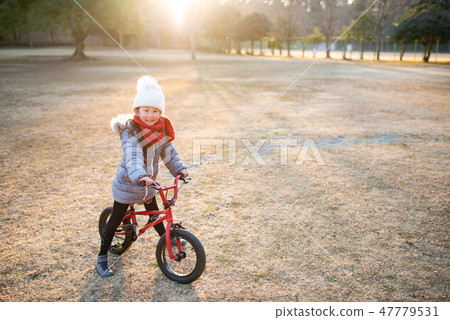 A girl playing with a bicycle 47779531