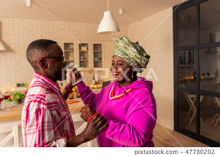 Delighted nice man holding hands of his wife 47780202