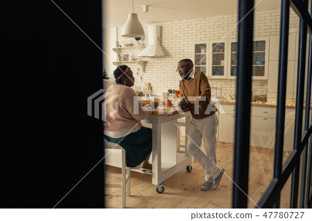 Nice pleasant couple talking in the kitchen Nice pleasant couple talking in the kitchen 47780727