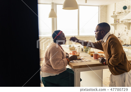 Nice afro American man feeding his beloved wife 47780729