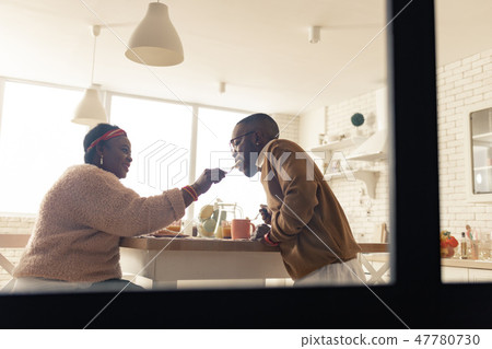Positive joyful woman feeding her beloved husband 47780730