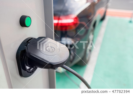 Close up of the power supply plugged into an electric car being charged. Electric car charging Close up of the power supply plugged into an electric car being charged. Electric car charging 47782394