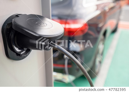Close up of the power supply plugged into an electric car being charged. Electric car charging Close up of the power supply plugged into an electric car being charged. Electric car charging 47782395