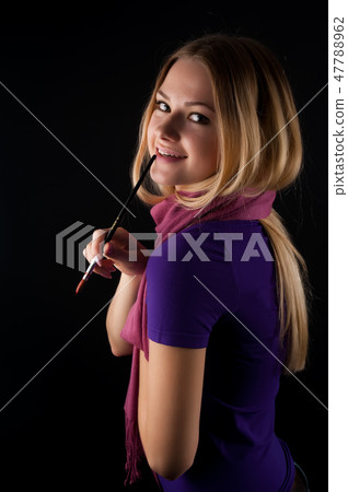 Attractive young smiling woman with artist brush 47788962