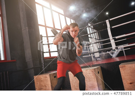 Great defence. Confident handsome athlete in sports clothing turning aside and practicing defence 47789851