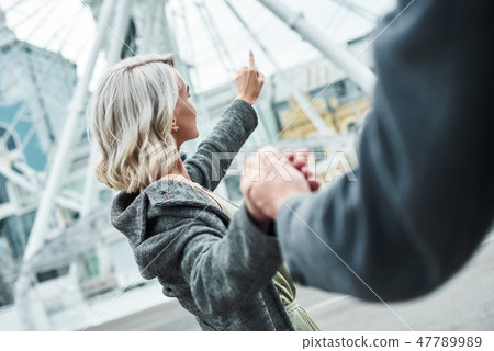Romantic date outdoors. Young couple walking at entertainment park holding hands woman close-up Romantic date outdoors. Young couple walking at entertainment park holding hands woman close-up 47789989
